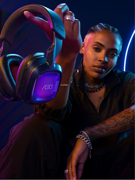 Gamer holding an Astro gaming headset with illuminated ear cup